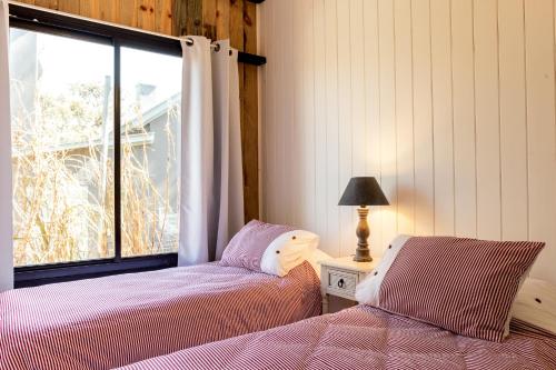 a bedroom with two beds next to a window at Yaku Beach in José Ignacio