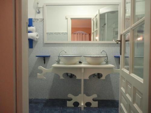 Hotel Rural las Cinco Ranas في Brazatortas: حمام مغسلتين ومرآة