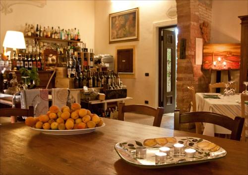 a bowl of oranges on a table in a restaurant at Le Vecchie Cantine in Chianni