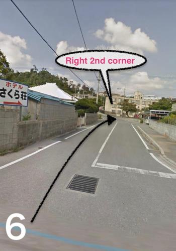 a view of an empty street with a sign that reads fight and corner at Guest House Umusan in Nago