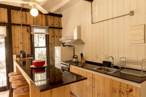 a kitchen with a black counter top and a refrigerator at Zulu Beach in José Ignacio