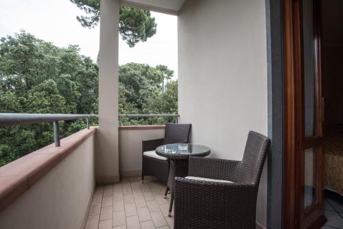 a balcony with a table and chairs and a window at Hotel Kyrton in Forte dei Marmi