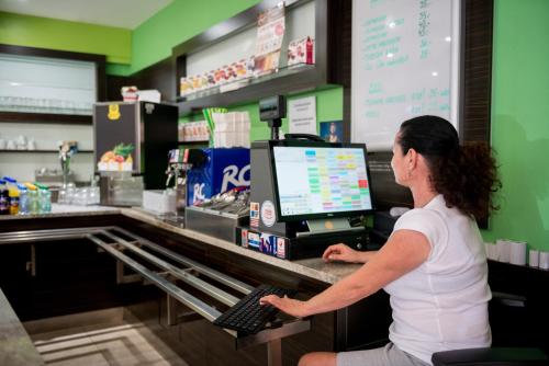 a woman sitting at a cash register in a store at Hotel Mlynska in Uherské Hradiště
