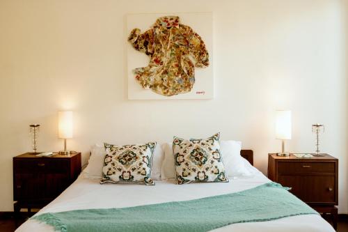 a bedroom with a bed with pillows and a picture on the wall at Cdl in José Ignacio