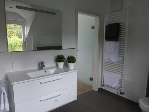 bagno bianco con lavandino e specchio di York Cottage Heaven a Traben-Trarbach