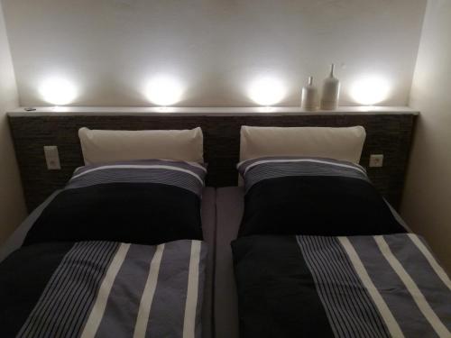 2 camas en una habitación con luces en la pared en Ferien-Appartement Goldhausen, en Goldhausen