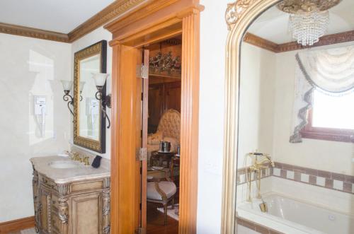 a bathroom with a tub and a sink and a mirror at The Hotel Magnolia in Foley