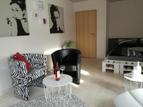 ein Wohnzimmer mit einem Sofa und einem Stuhl in der Unterkunft Ferien-Appartement Goldhausen in Goldhausen