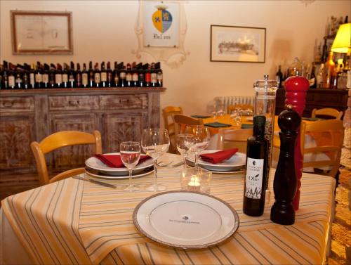 a table with a plate and wine glasses on it at Le Vecchie Cantine in Chianni