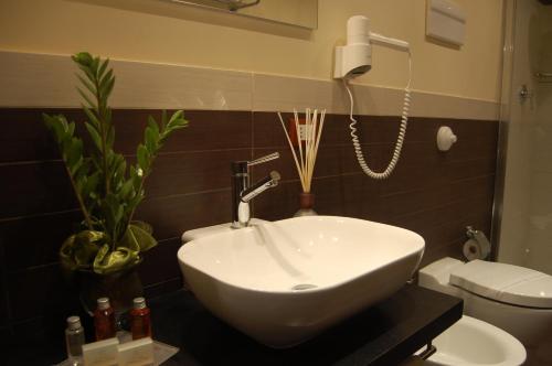a bathroom with a white sink and a toilet at Andrea Doria Hotel in Marina di Ragusa