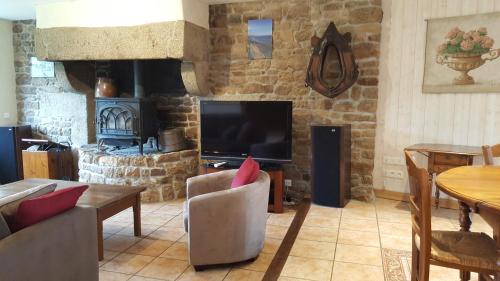 a living room with a television and a fireplace at Le BOCAGE in Sartilly