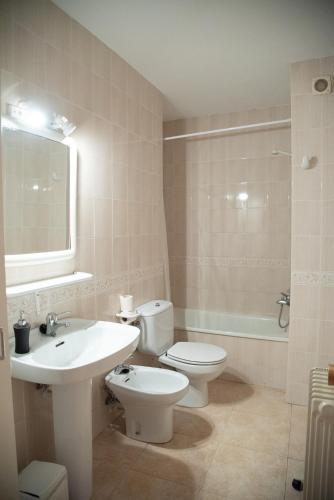a bathroom with a toilet and a sink and a tub at Casa Rural Cal Bosch in Llagunes
