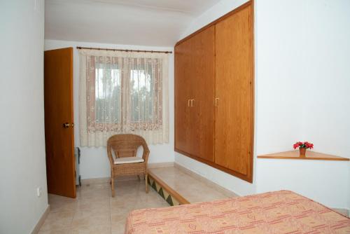 - une chambre avec un lit, une chaise et une fenêtre dans l'établissement Casa Rural Cal Bosch, à Llagunes