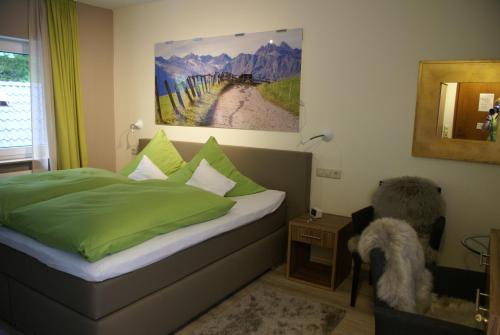 a bedroom with a bed with green sheets and a mirror at Hotel Storchen in Rheinfelden