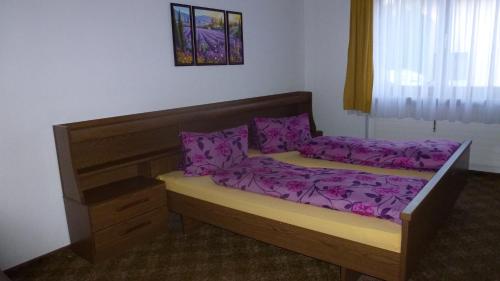 a bedroom with a bed with purple sheets at Apartement Hasenauer in Fieberbrunn