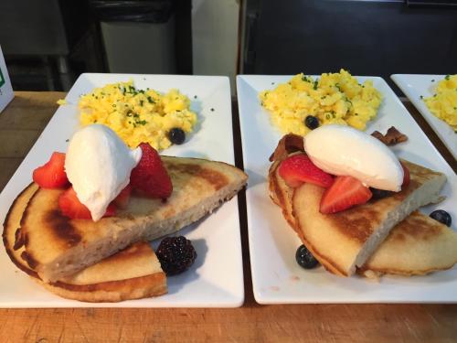 two plates of breakfast foods with fruit on them at Mirabelle Inn & Restaurant in Solvang