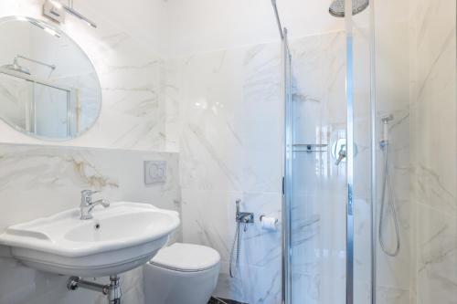 a white bathroom with a sink and a shower at 3110 ArtHotel in Florence