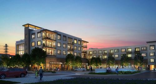 a rendering of a building with people walking in a parking lot at Bluebird Suites in Menlo Park in Menlo Park