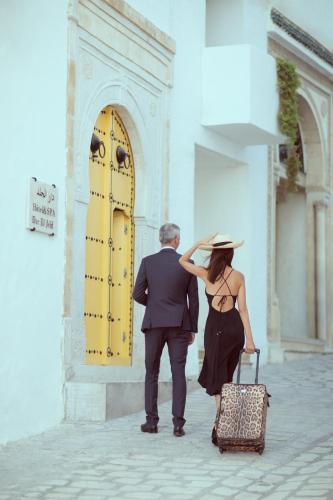 a man and a woman walking in front of a building at Dar El Jeld Hotel and Spa in Tunis