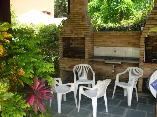 - un ensemble de chaises blanches assises sur une terrasse dans l'établissement Chalés Santorini, à Caraguatatuba