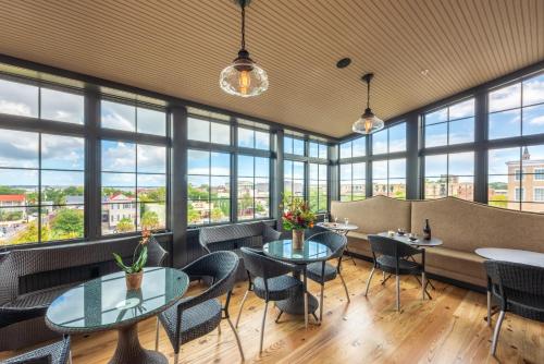 a restaurant with tables and chairs and large windows at Andrew Pinckney Inn in Charleston