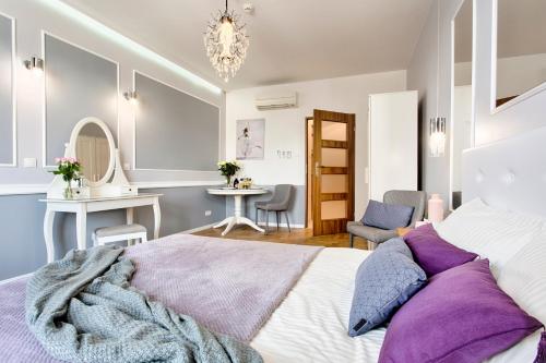 - une chambre avec un lit, une table et des chaises dans l'établissement Main Square Apartments, à Cracovie
