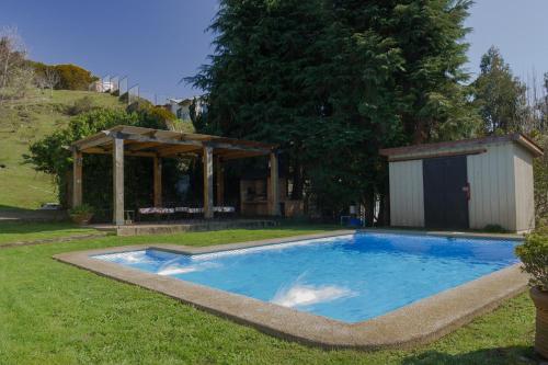 a swimming pool in a yard with a gazebo at Cabañas Peumayen in Puerto Varas