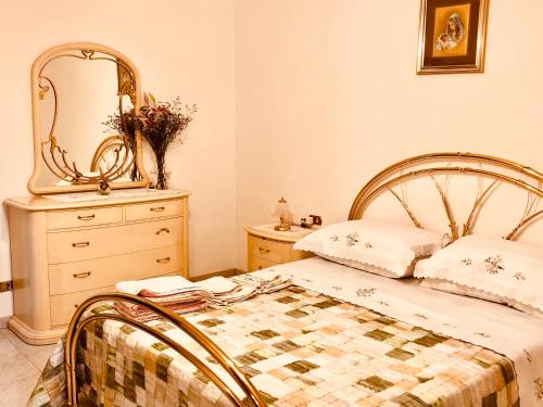 una camera da letto con un letto con specchio e un comò di Agriturismo Vista Sole a Mercatale