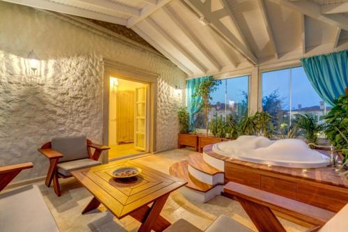 アラカティにあるBel Canto Alaçatı Hotelのバスルーム(バスタブ、テーブル付)