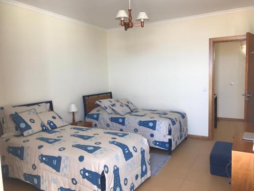 um quarto com 2 camas com lençóis azuis e brancos em Duplex Ocean View em Porto Santo