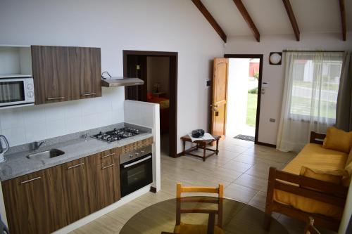 uma cozinha com um lavatório e um fogão forno superior em Apart Hotel Y Cabanas Vegasur em La Serena
