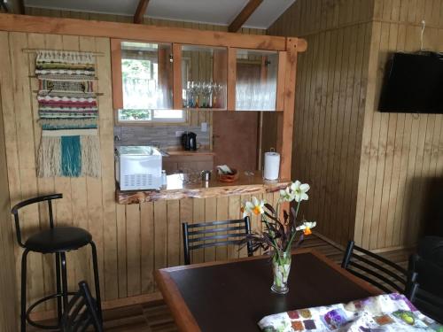 a kitchen with a table with a vase of flowers at Cabañas 4 Volcanes Frutillar in Frutillar