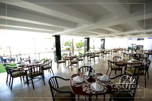 a dining room with tables and chairs on a balcony at Hotel Gran Plaza & Convention Center in Guanajuato
