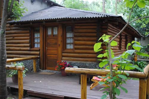 Cabaña de madera con terraza con puerta en Cabañas Tehuel en Las Gaviotas