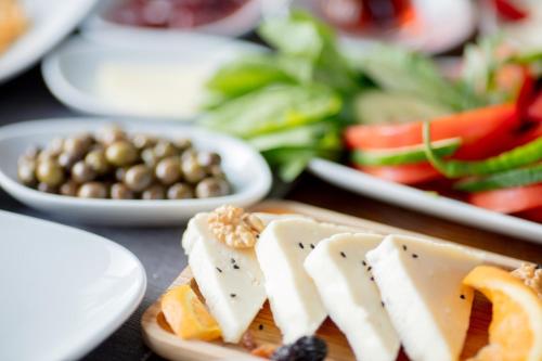 un piatto di alimenti con formaggio e verdure su un tavolo di Bel Canto Alaçatı Hotel ad Alaçatı