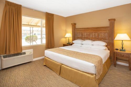 a bedroom with a large bed and a window at Travelodge by Wyndham Hawthorne in Hawthorne
