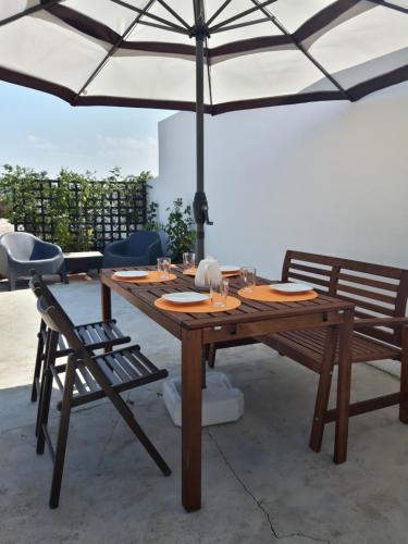 a wooden table with two chairs and an umbrella at Cozy Place in Sintra