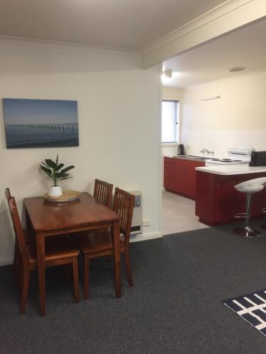 a room with a table and chairs and a kitchen at Old Pier Apartments in Bridport