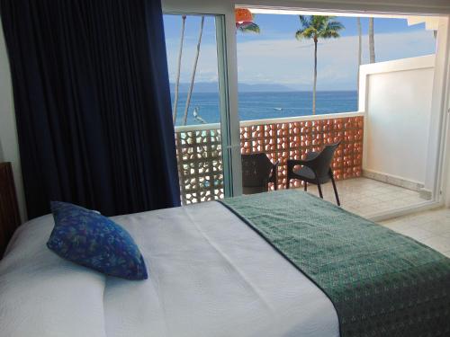 a bedroom with a bed and a view of the ocean at Hotel Rosita in Puerto Vallarta