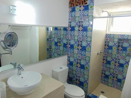 
a bathroom with a sink, toilet, and bathtub at Hotel Rosita in Puerto Vallarta
