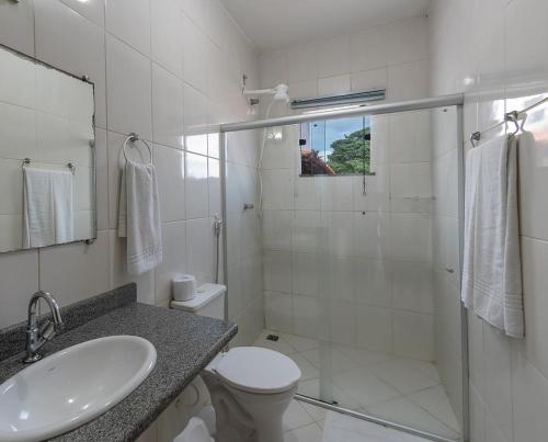 a bathroom with a sink and a toilet and a shower at Pousada Lua e Mar in Ilhéus