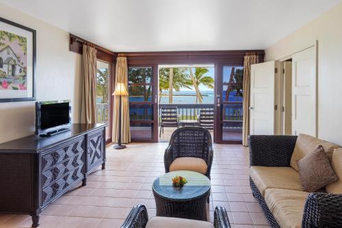 a living room with a couch and a tv at The Naviti Resort in Korolevu