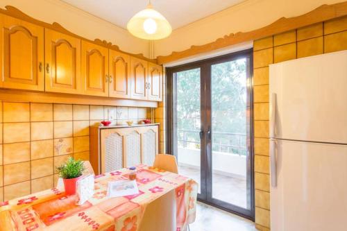 a kitchen with a table and a refrigerator at Modern Condo at the Beach in Sounio