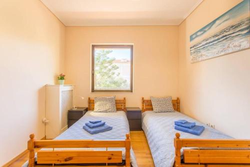 two beds in a room with two benches at Modern Condo at the Beach in Sounio