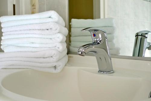 a bathroom sink with white towels and a faucet at Appartementen Valkenburg in Valkenburg