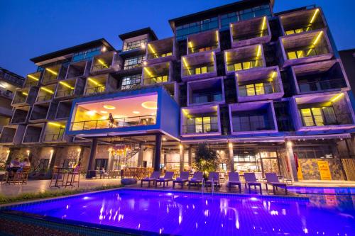 a hotel with a swimming pool in front of a building at Inthira Vangvieng in Vang Vieng