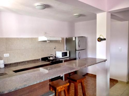uma cozinha com uma bancada e um frigorífico em Casa en Mina Clavero em Mina Clavero