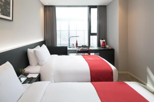 a hotel room with two beds and a window at Aiden by Best Western Cheongdam in Seoul