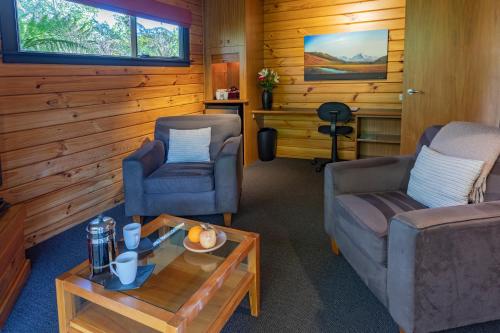 a living room with two chairs and a coffee table at Westwood Lodge in Franz Josef