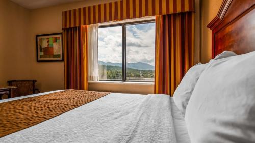 a bedroom with a bed and a large window at Best Western White Mountain Inn in Franconia
